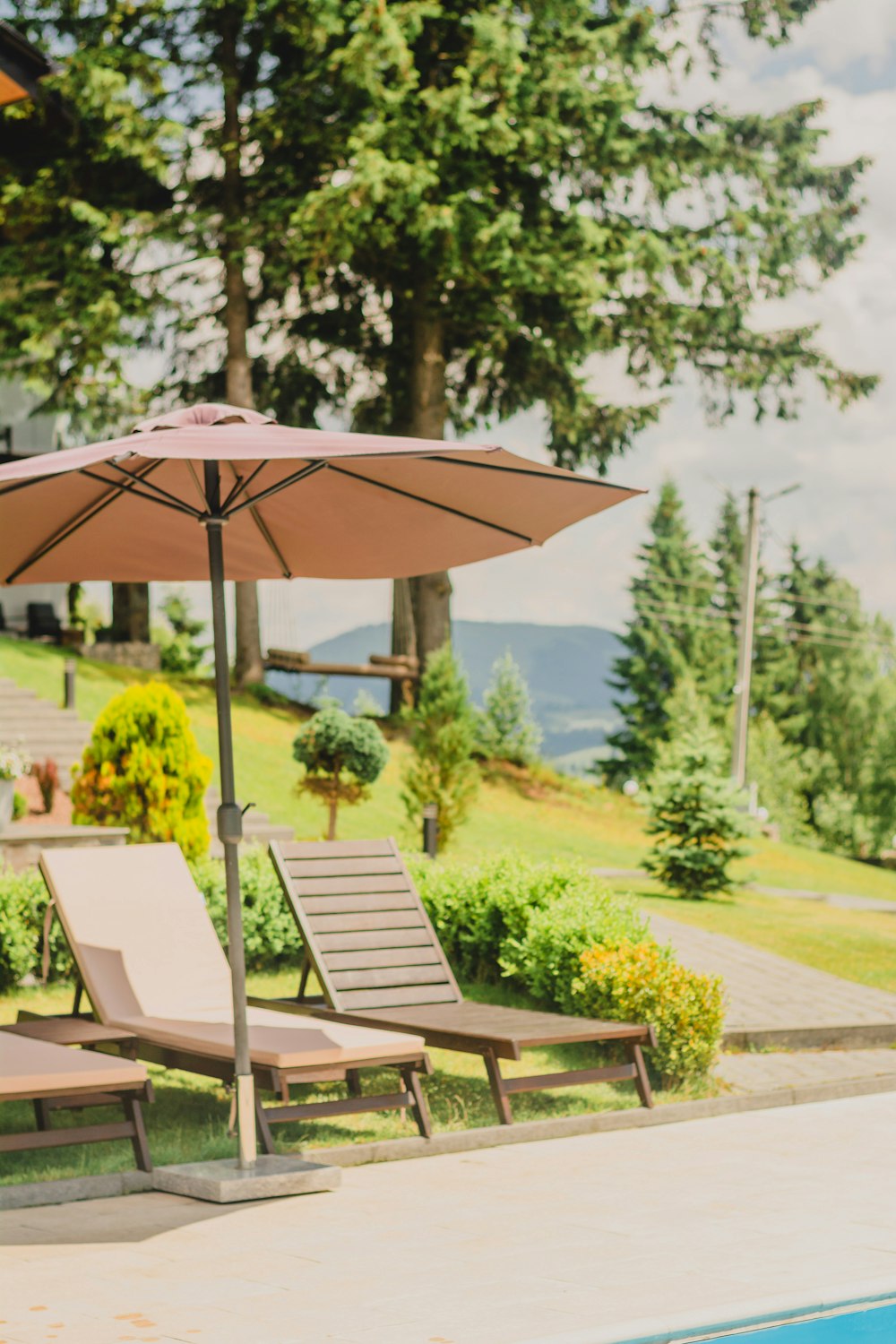 a couple of lawn chairs sitting next to a swimming pool