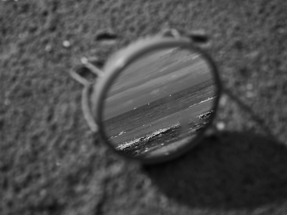 a close up of a magnifying glass with a beach in the background