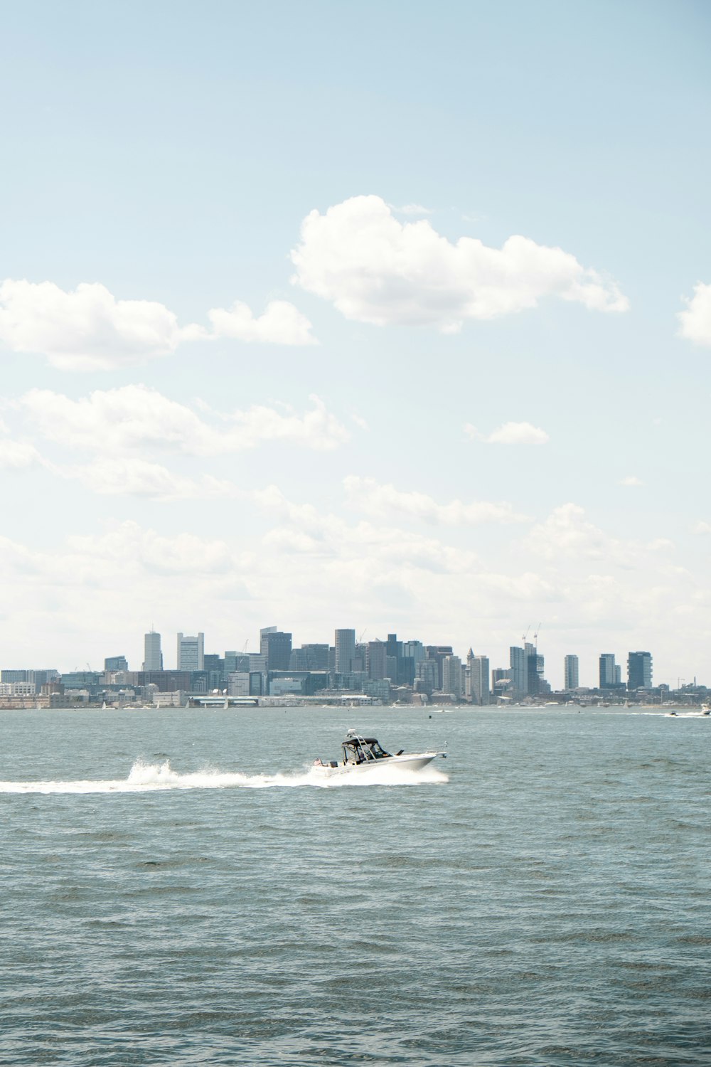 a boat is traveling across the water in front of a city