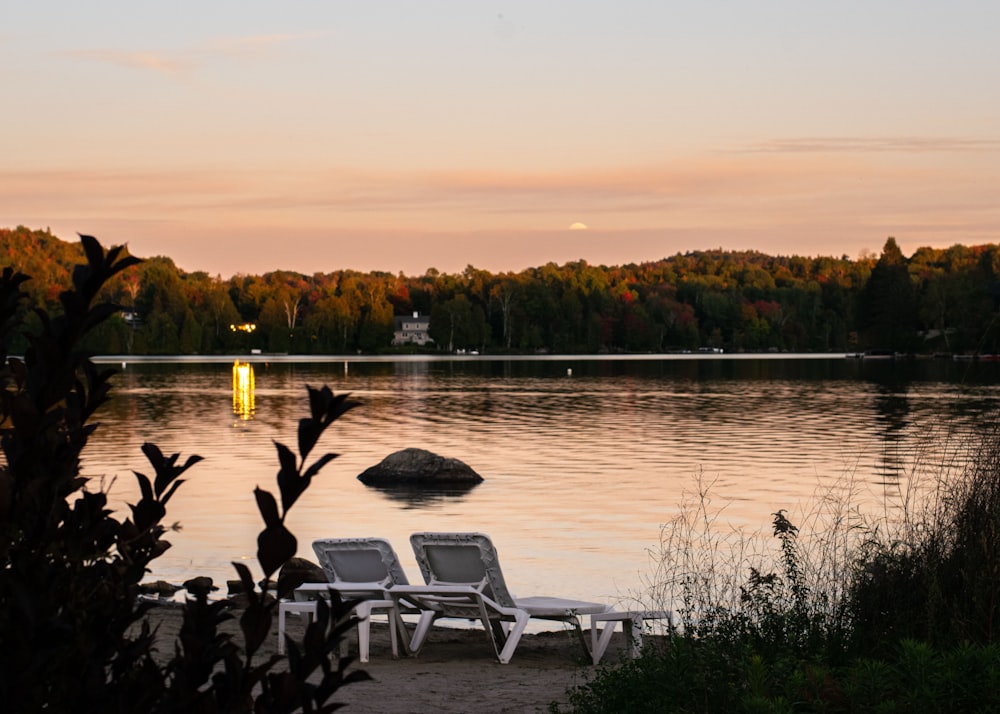 a couple of lawn chairs sitting on top of a lake