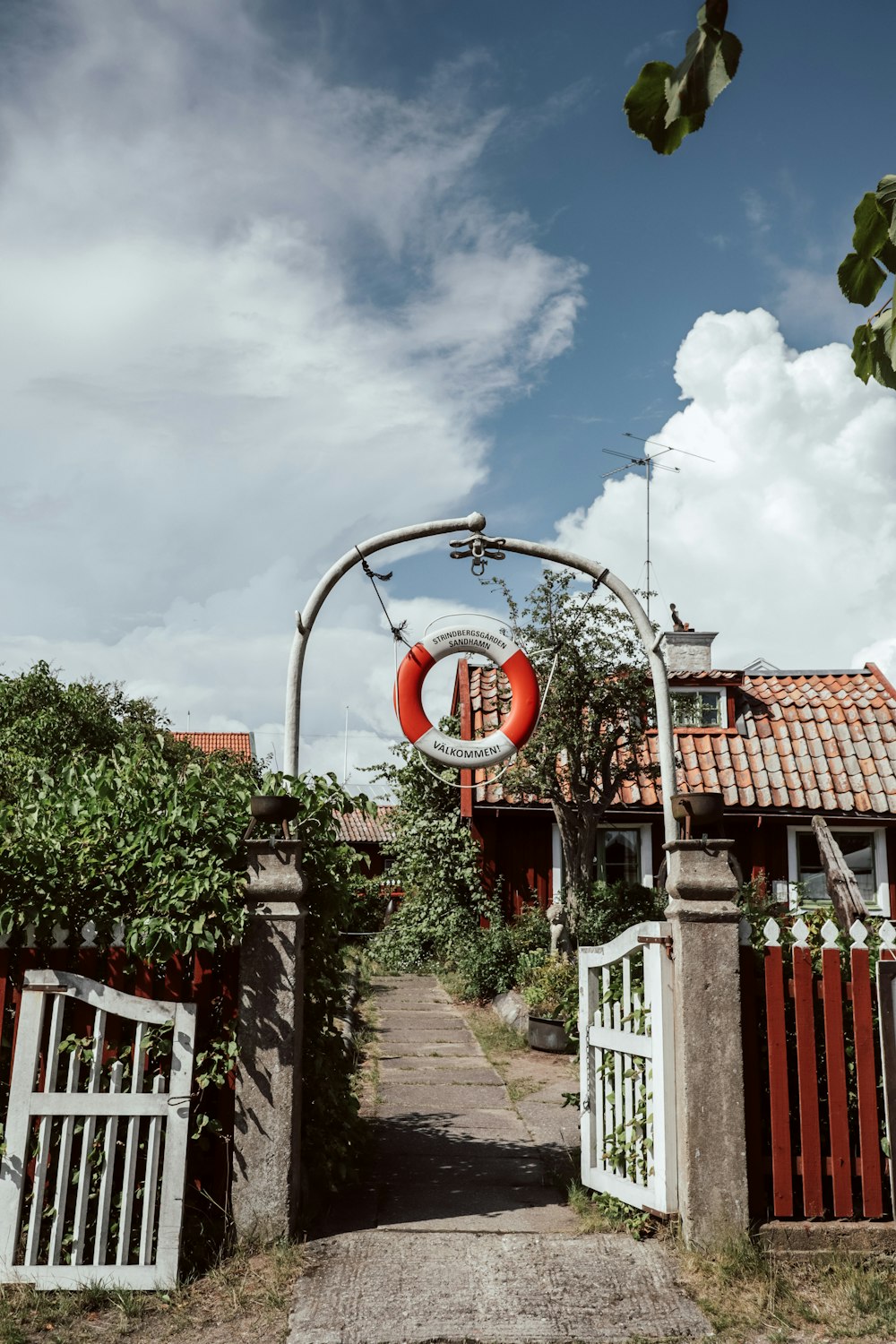 a red and white gate and some bushes and trees