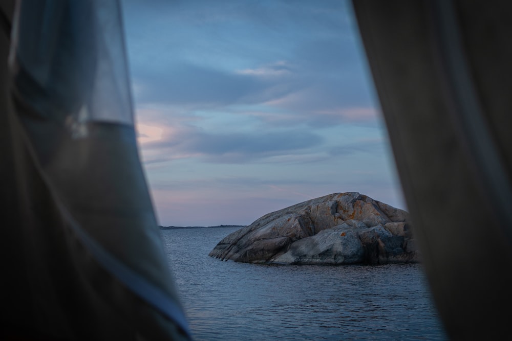 a large rock in the middle of a body of water