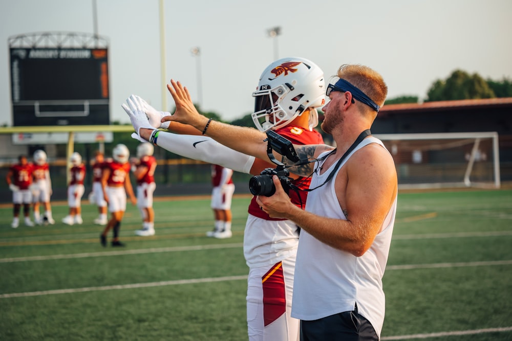 a football player is giving a high five to another player