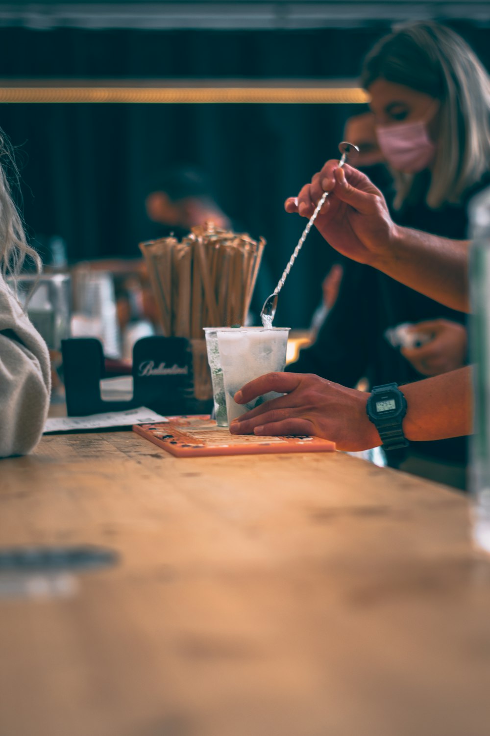 a woman sitting at a table with a drink in front of her