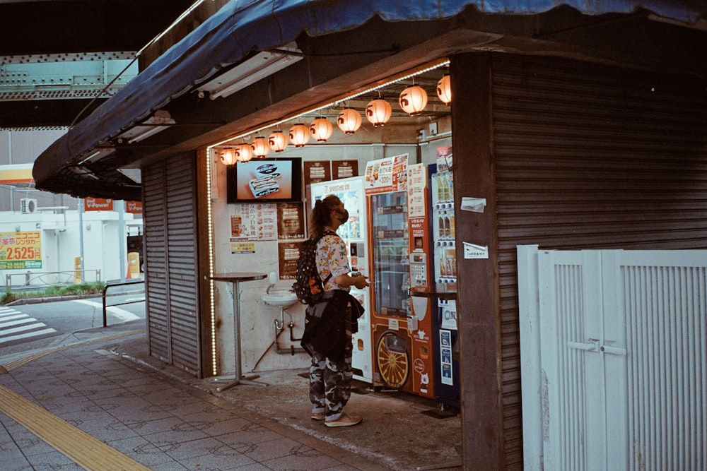 a woman standing in front of a vending machine