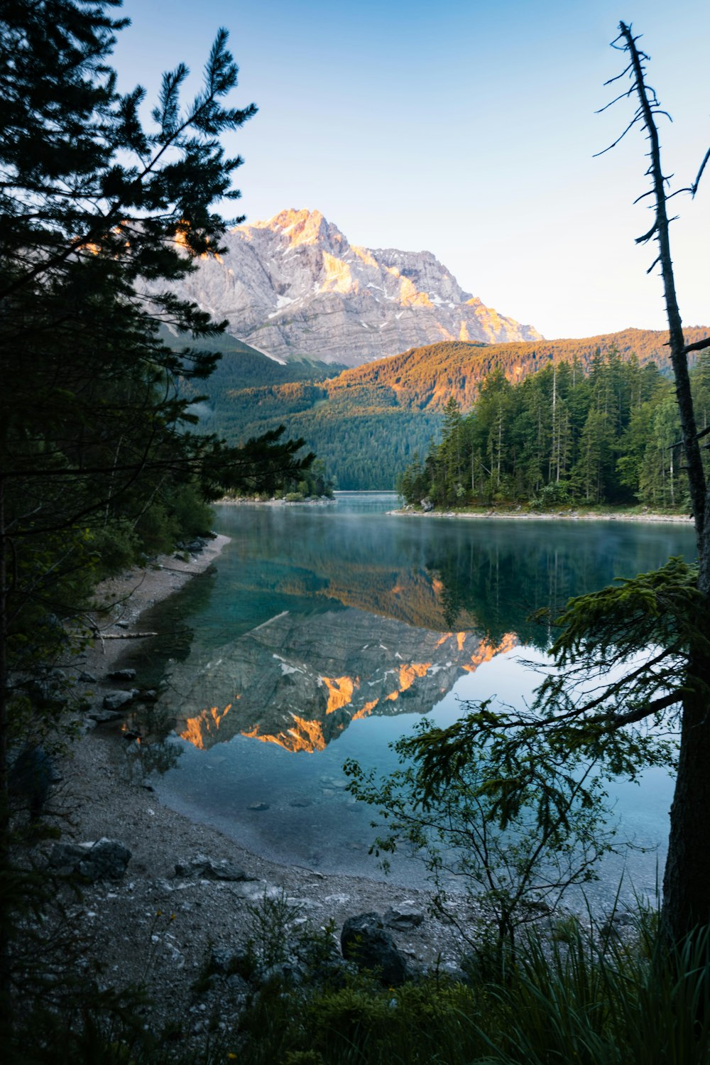 a lake surrounded by trees and mountains