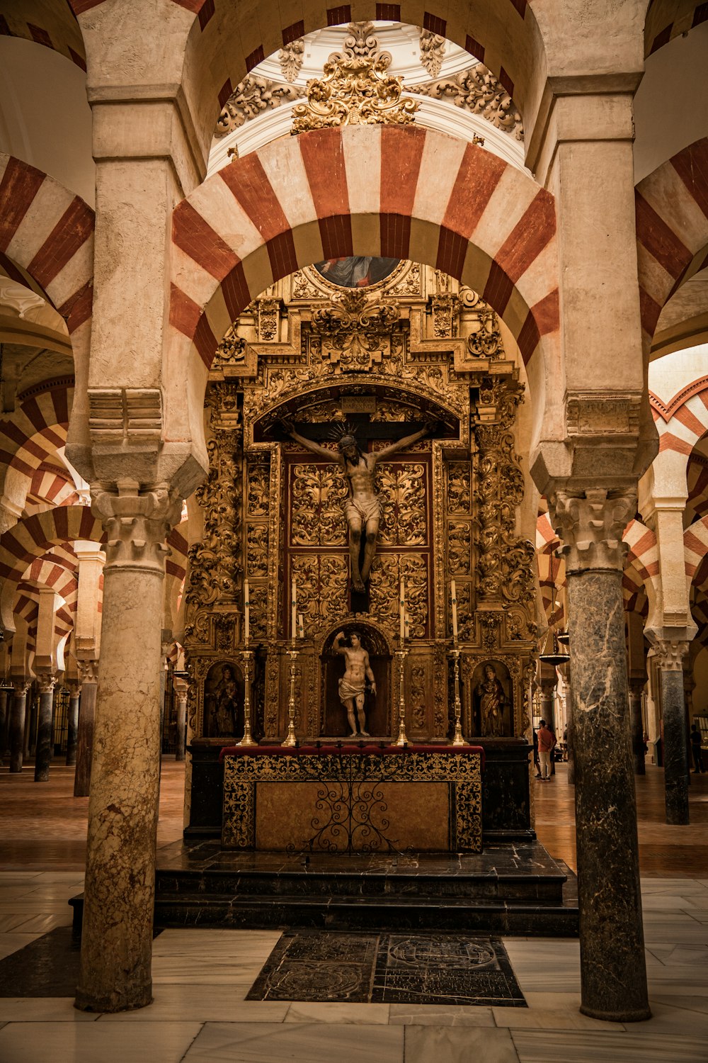 un autel orné dans une église avec des colonnes et des arcs
