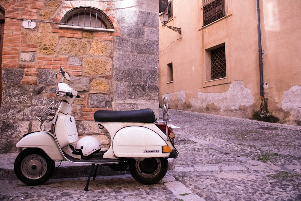a scooter parked on a cobblestone street
