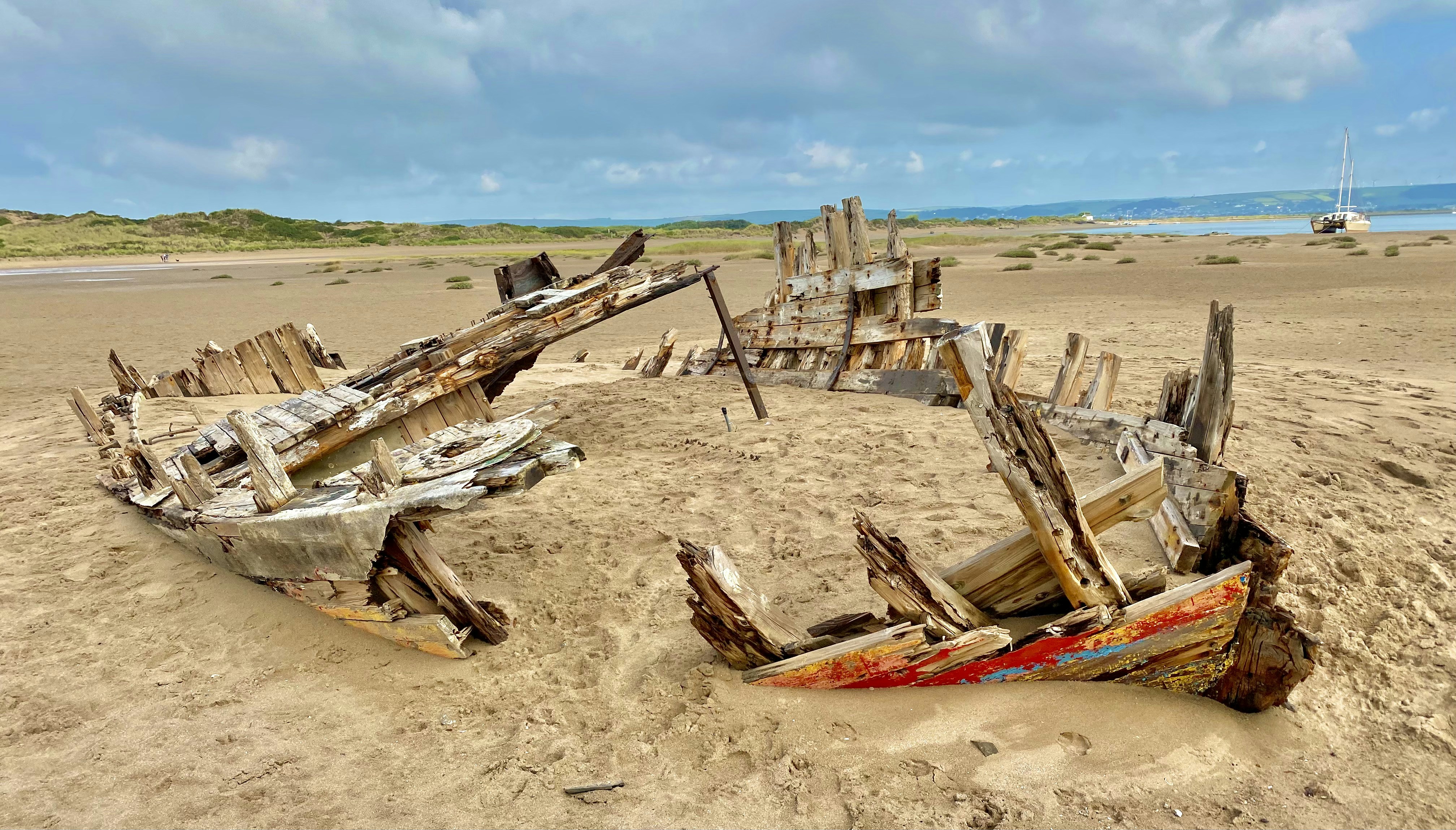 a wooden boat sitting on top of a sandy beach