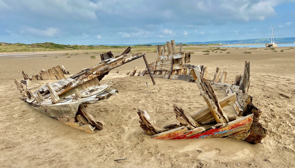 a wooden boat sitting on top of a sandy beach