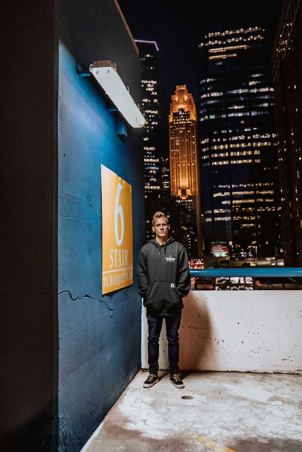 a man standing in front of a sign in a city