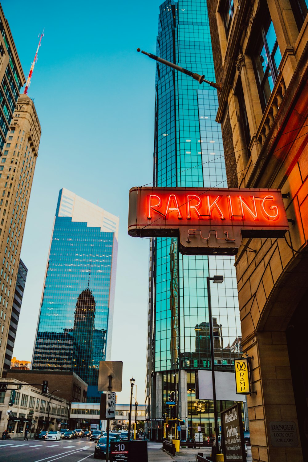 a red parking sign hanging from the side of a tall building