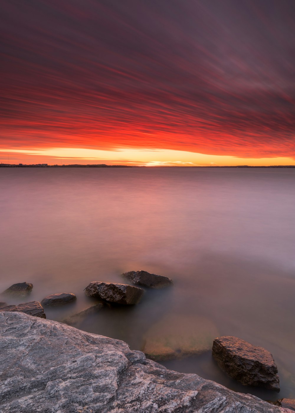 a long exposure photo of a sunset over the ocean