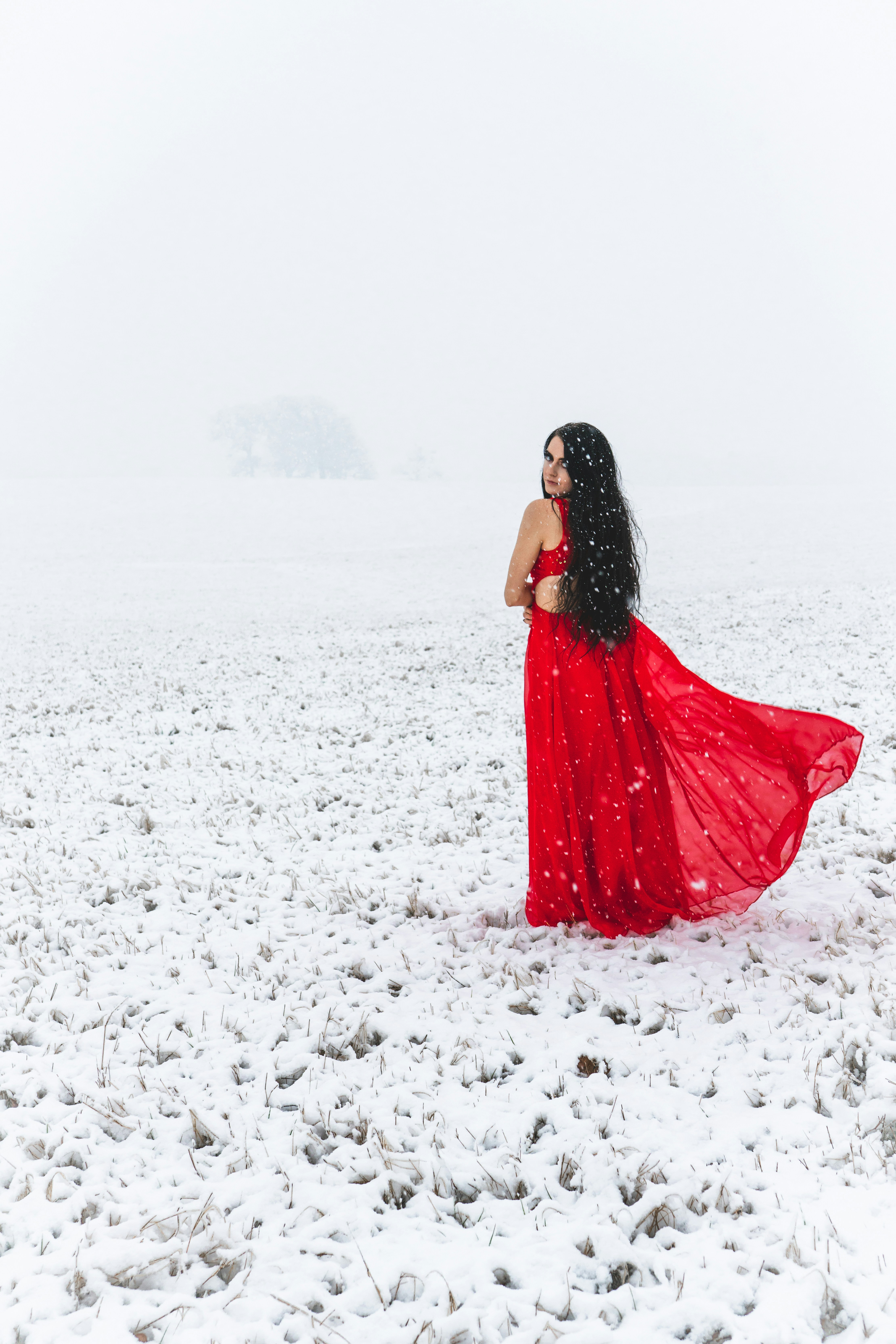 A woman in a red dress in the snow photo  Free Background Image on Unsplash