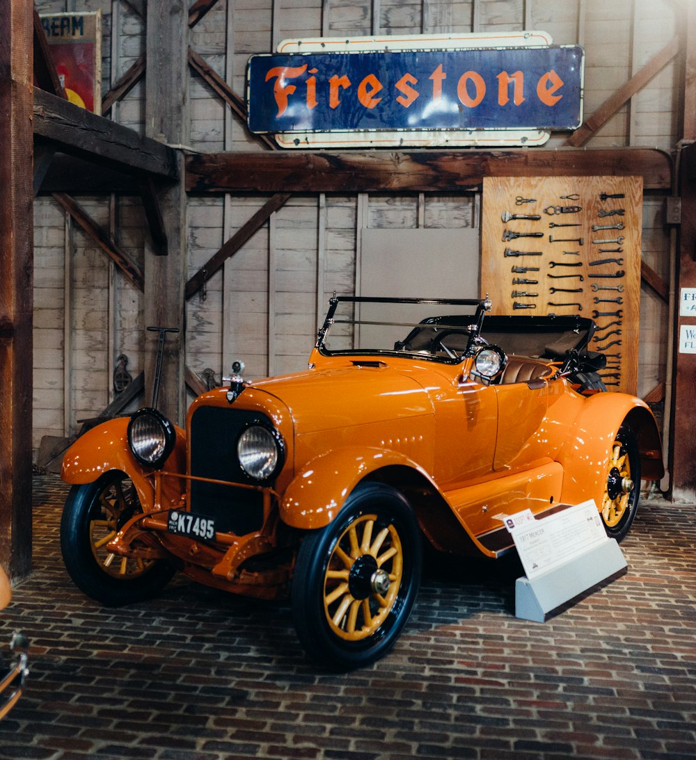 an orange car is parked inside of a building