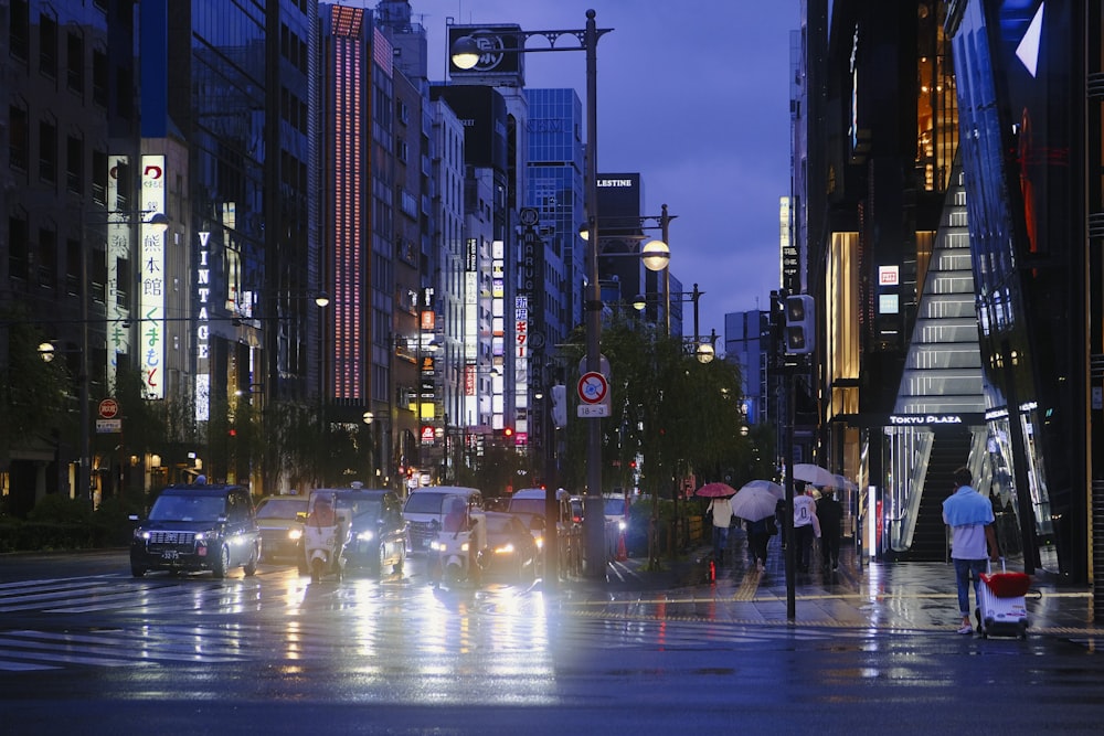 um grupo de pessoas andando através de uma rua segurando guarda-chuvas