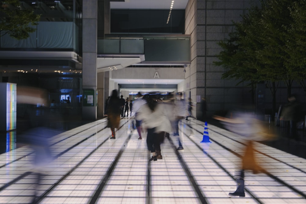 a group of people walking down a street next to a tall building