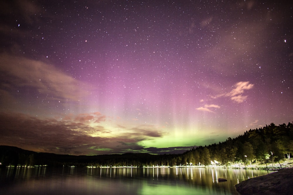 a purple and green aurora over a lake
