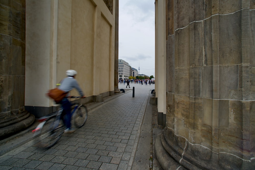 a man riding a bike down a street next to tall buildings