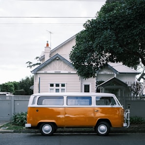 Family van loaded with luggage, parked outside a suburban home