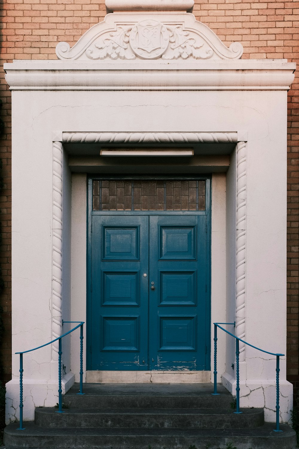 a blue door on a white brick building