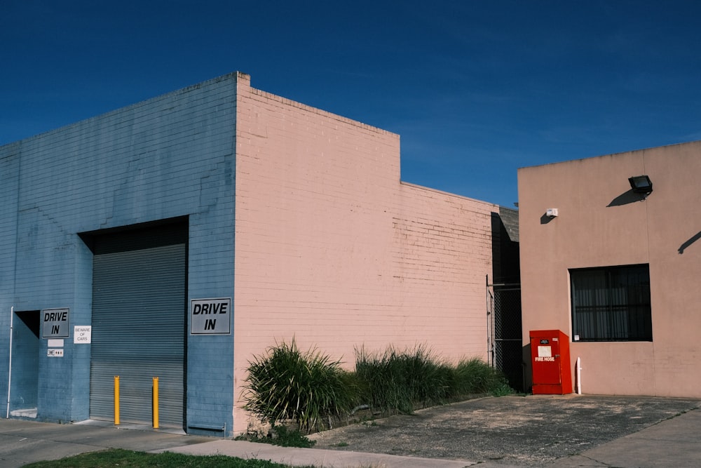 a pink building with a blue door and a red door