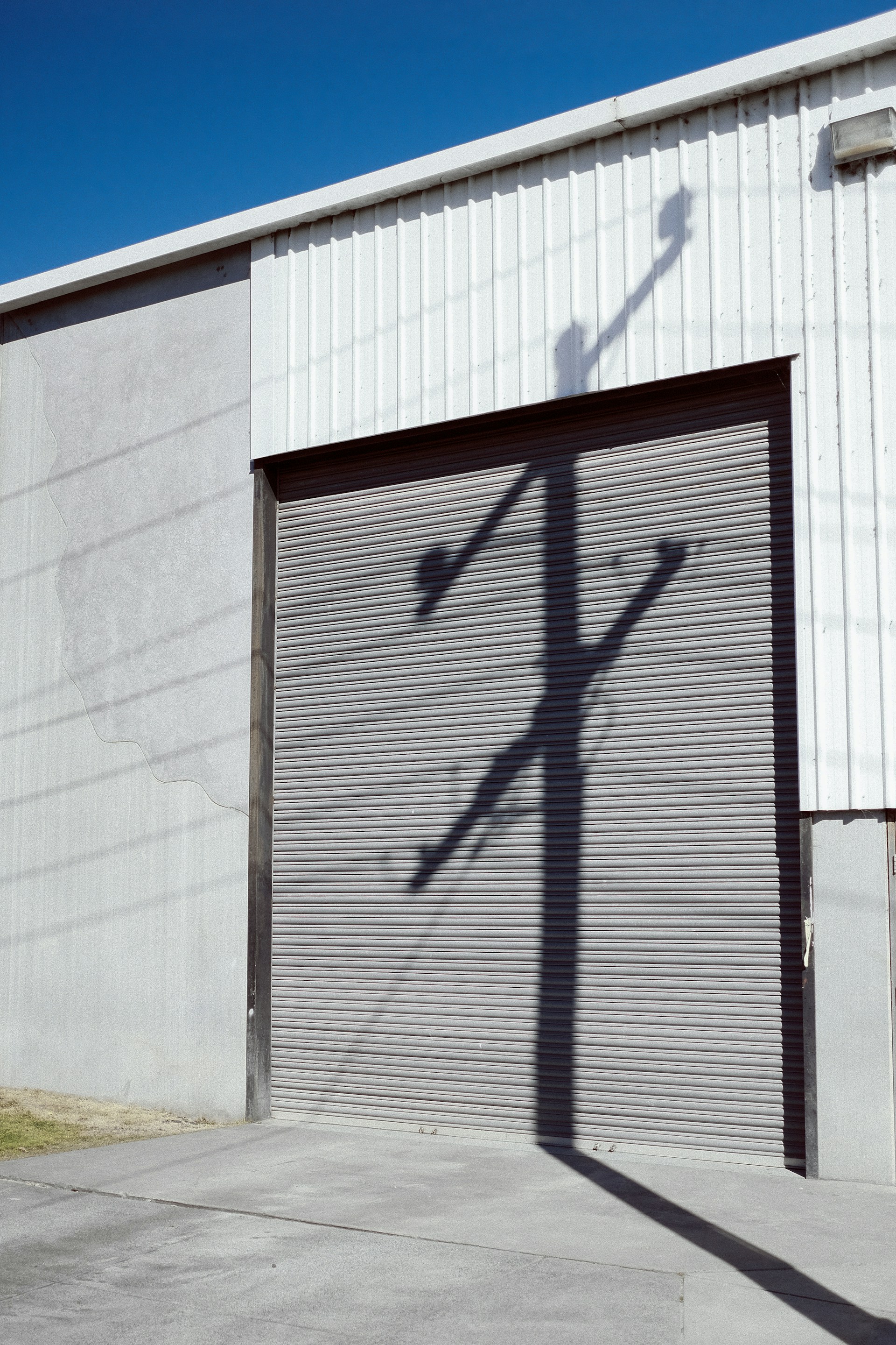 the shadow of a street light on a garage door