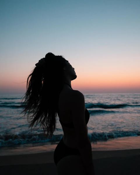 a woman in a bikini standing on the beach