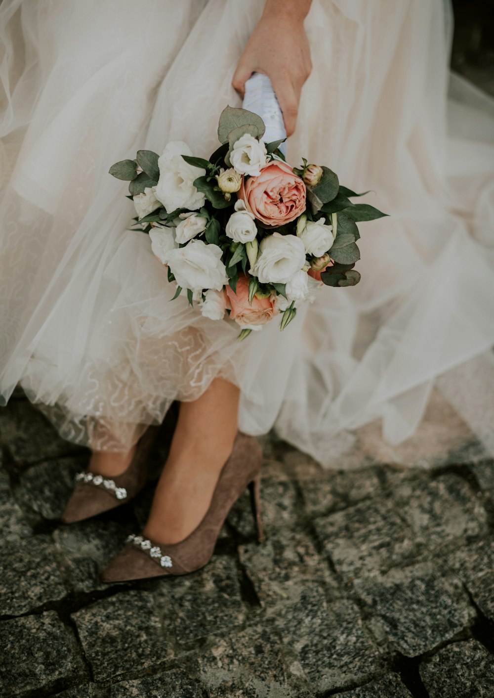 a woman in a wedding dress holding a bouquet of flowers