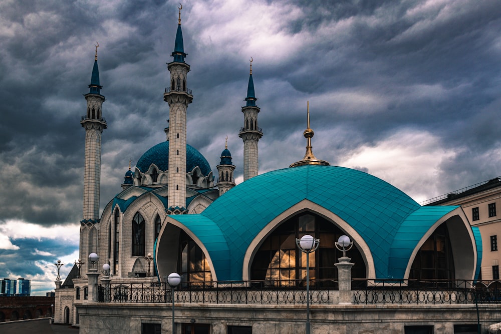 a large building with a blue roof and two towers