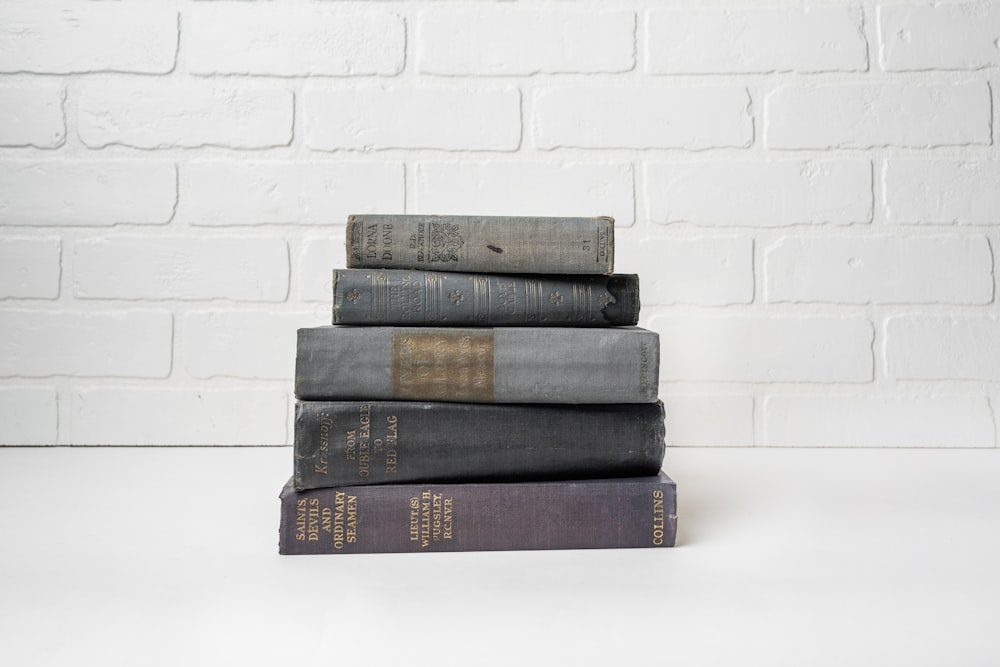 a stack of books sitting on top of a white table