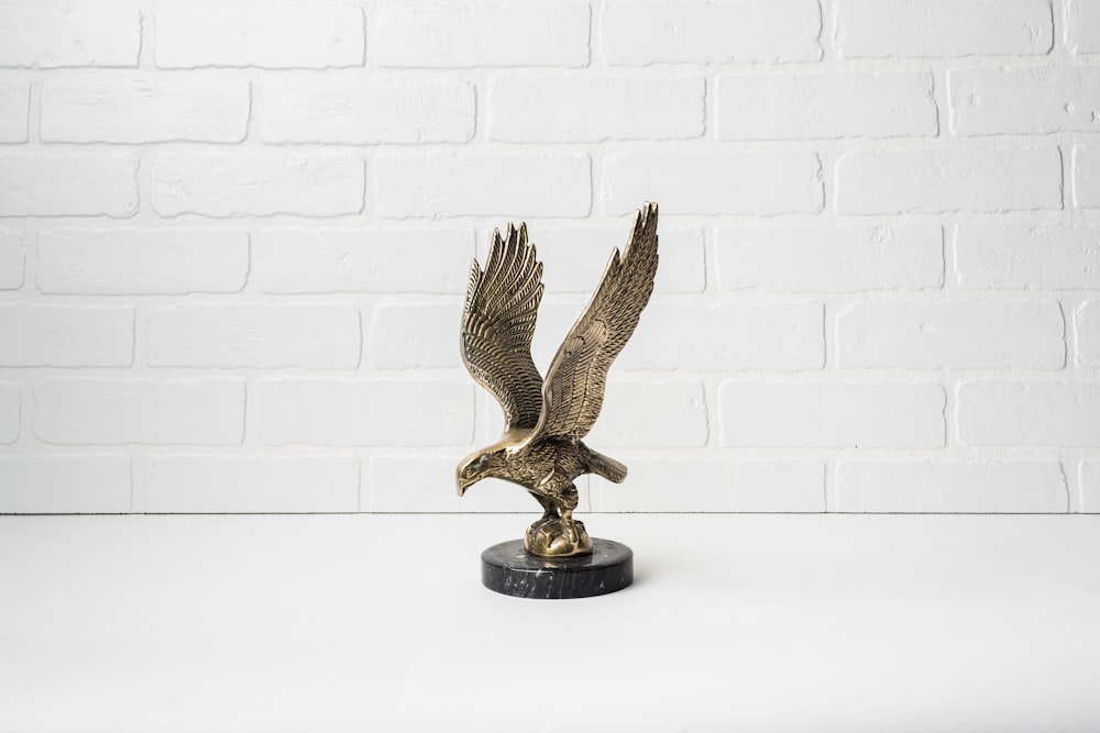 une statue en bronze d’un aigle sur un socle noir