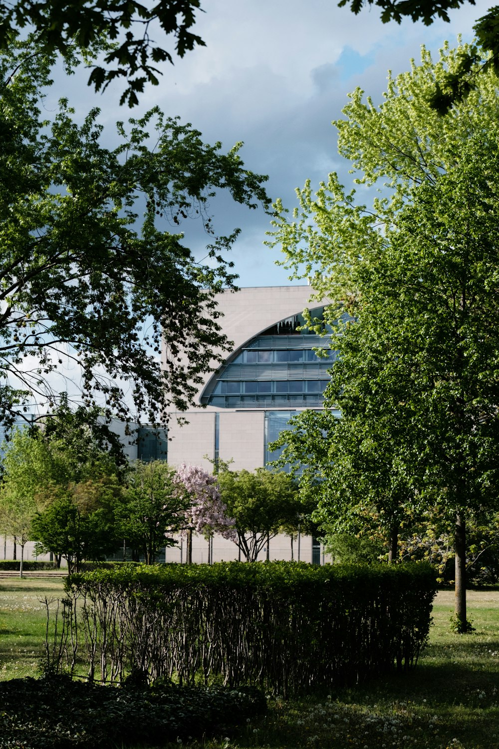 a building with a large circular window in the middle of a park