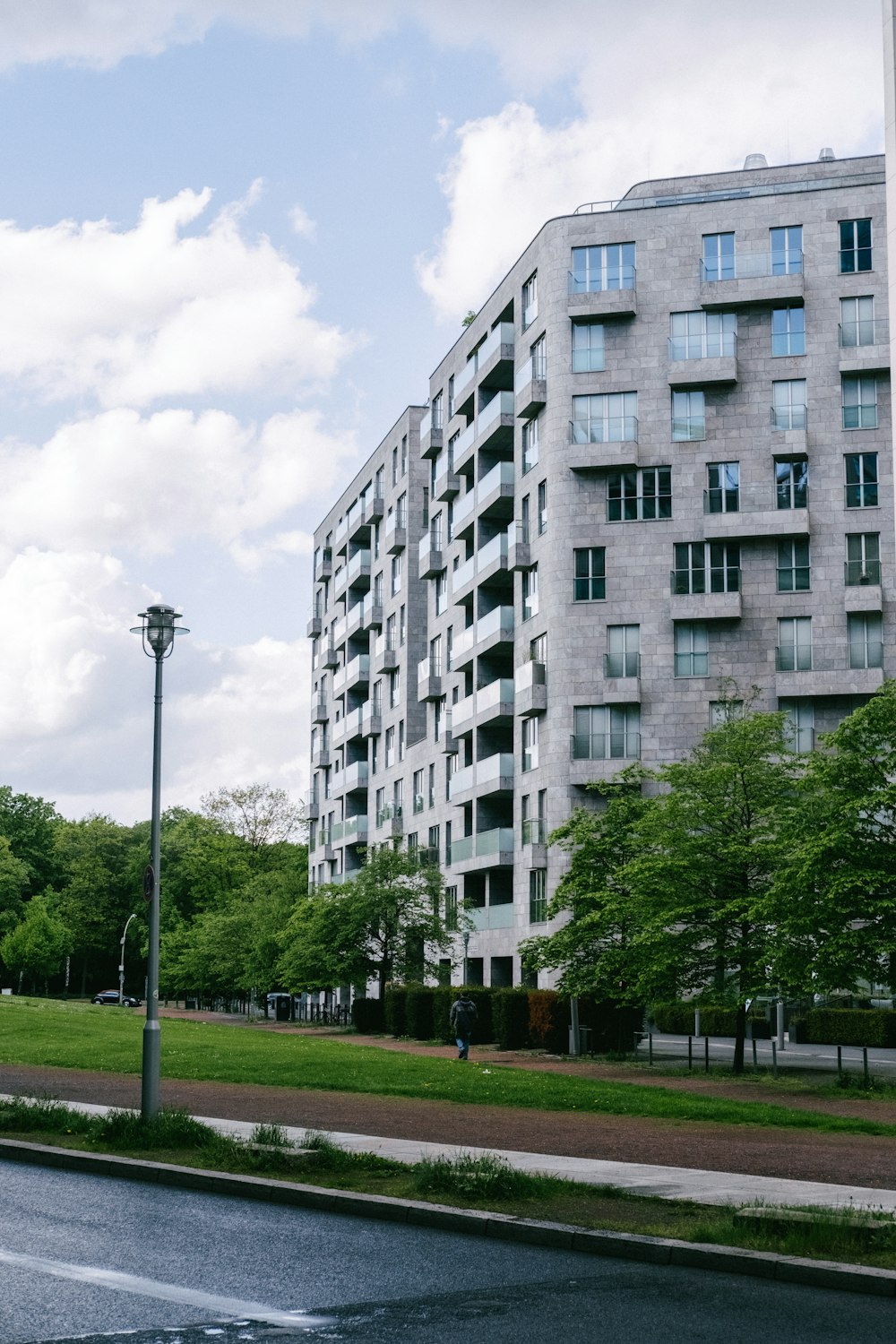 a tall building sitting next to a lush green park