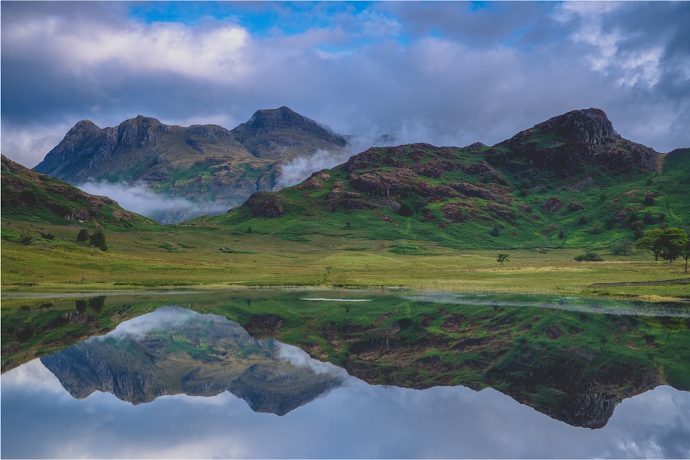 Une chaîne de montagnes avec un lac au premier plan