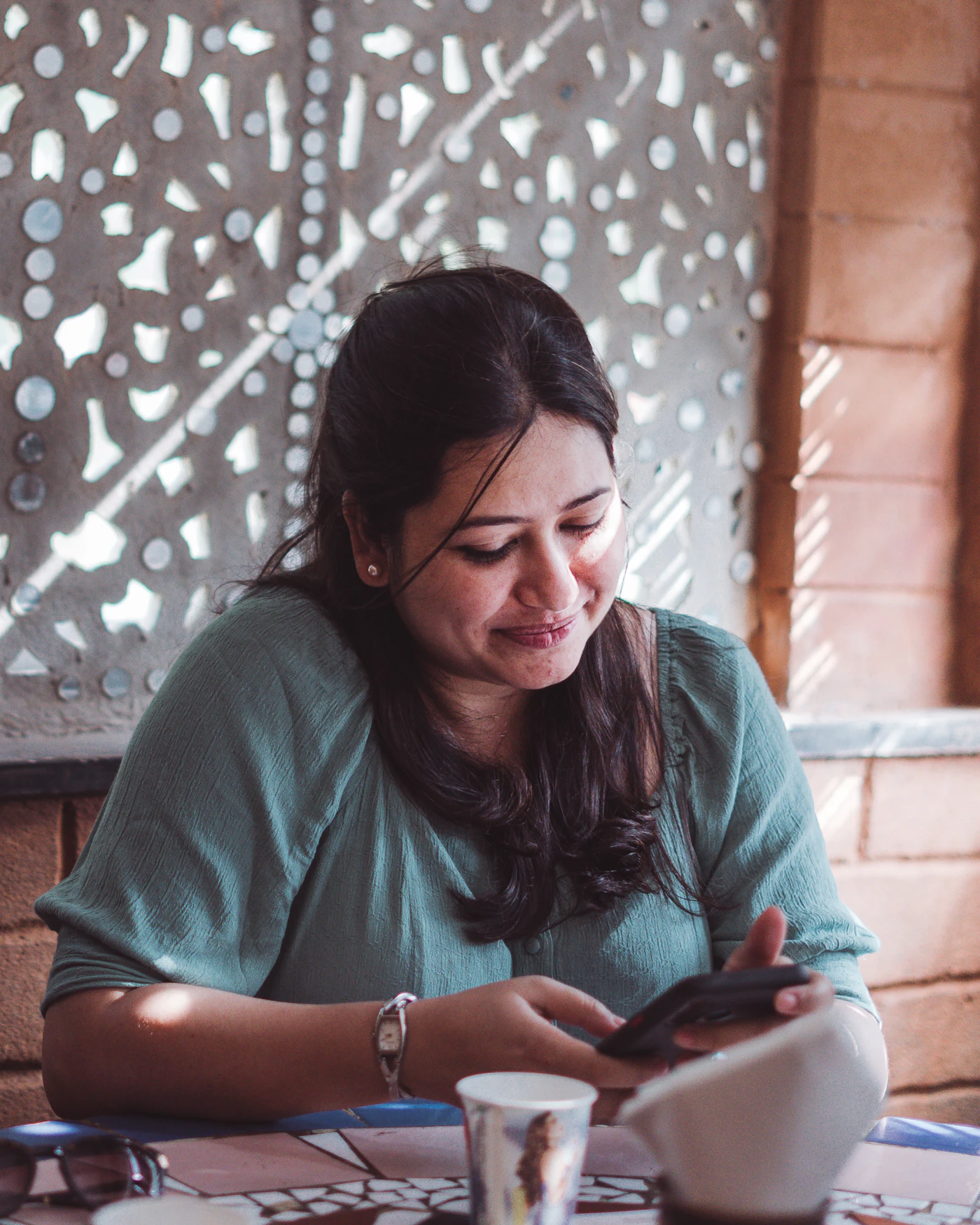 Woman checking her phone at a café table