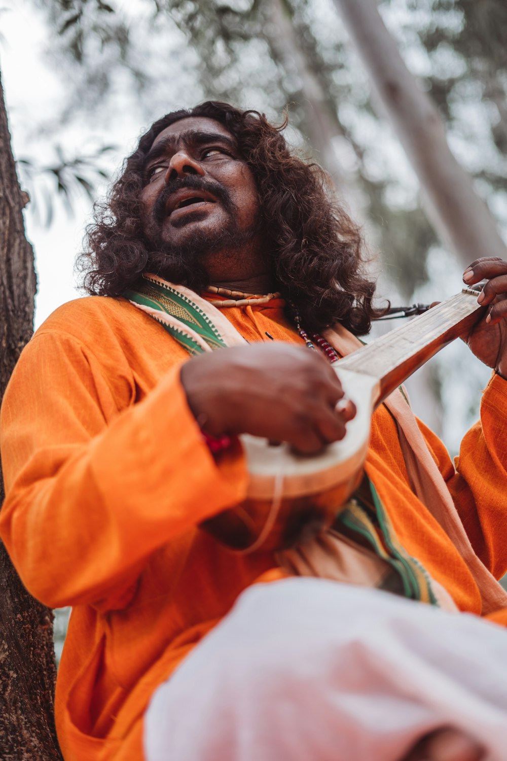 a man with long hair playing a musical instrument