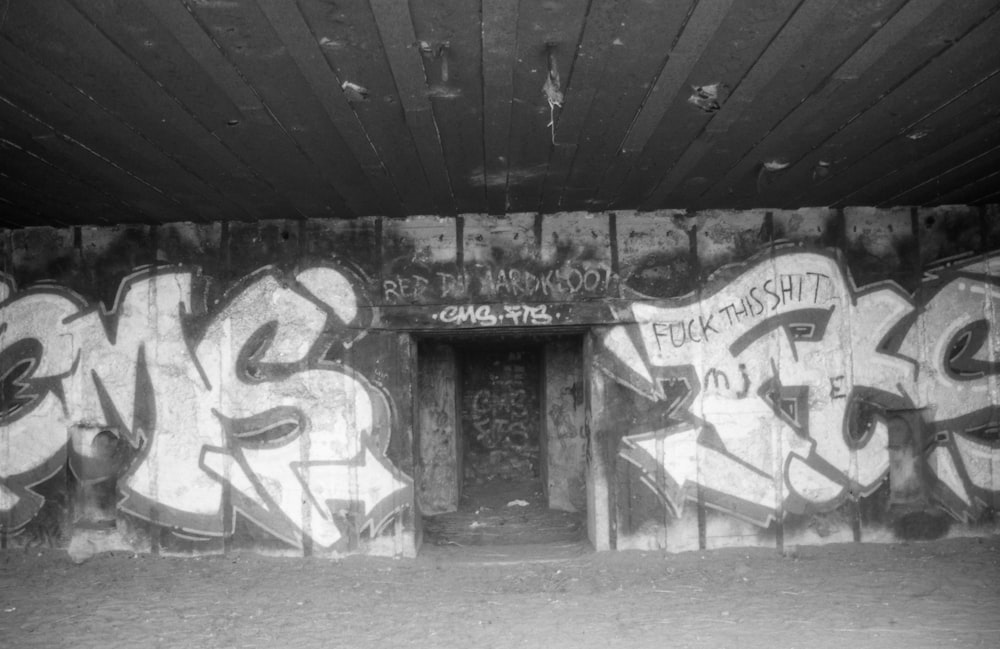 a black and white photo of graffiti on a wall