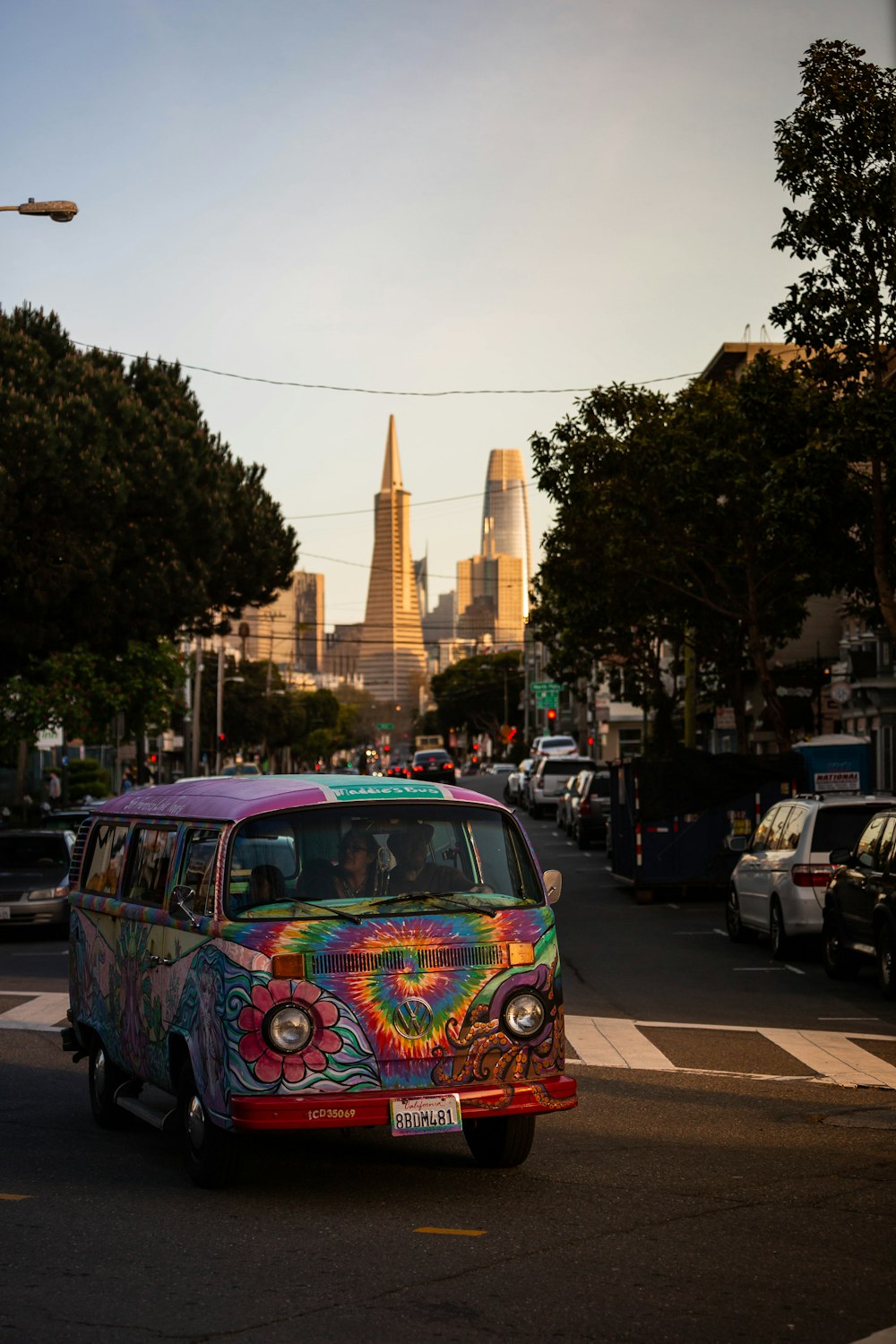 a colorful van driving down a city street