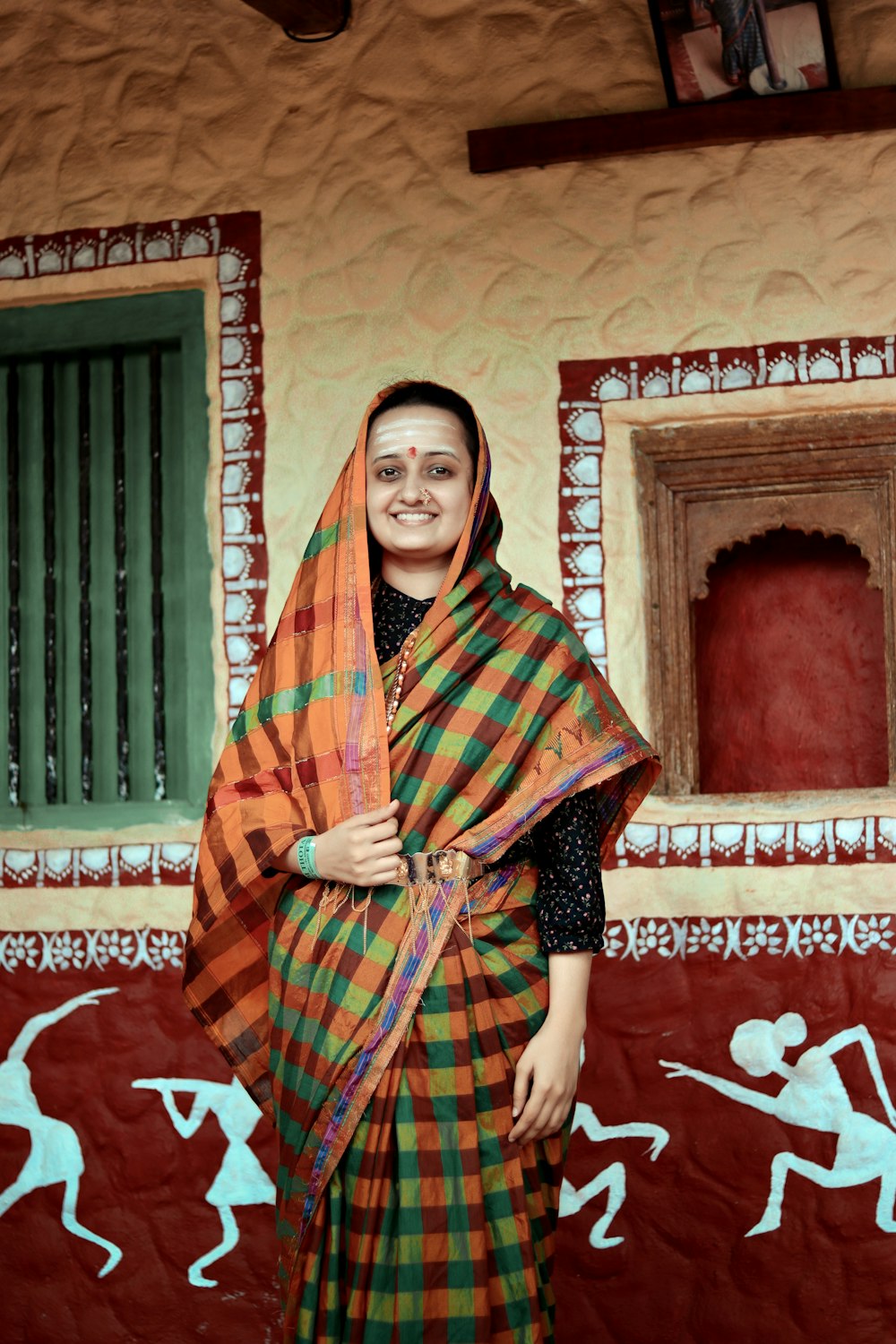 a woman standing in front of a wall with a painting on it