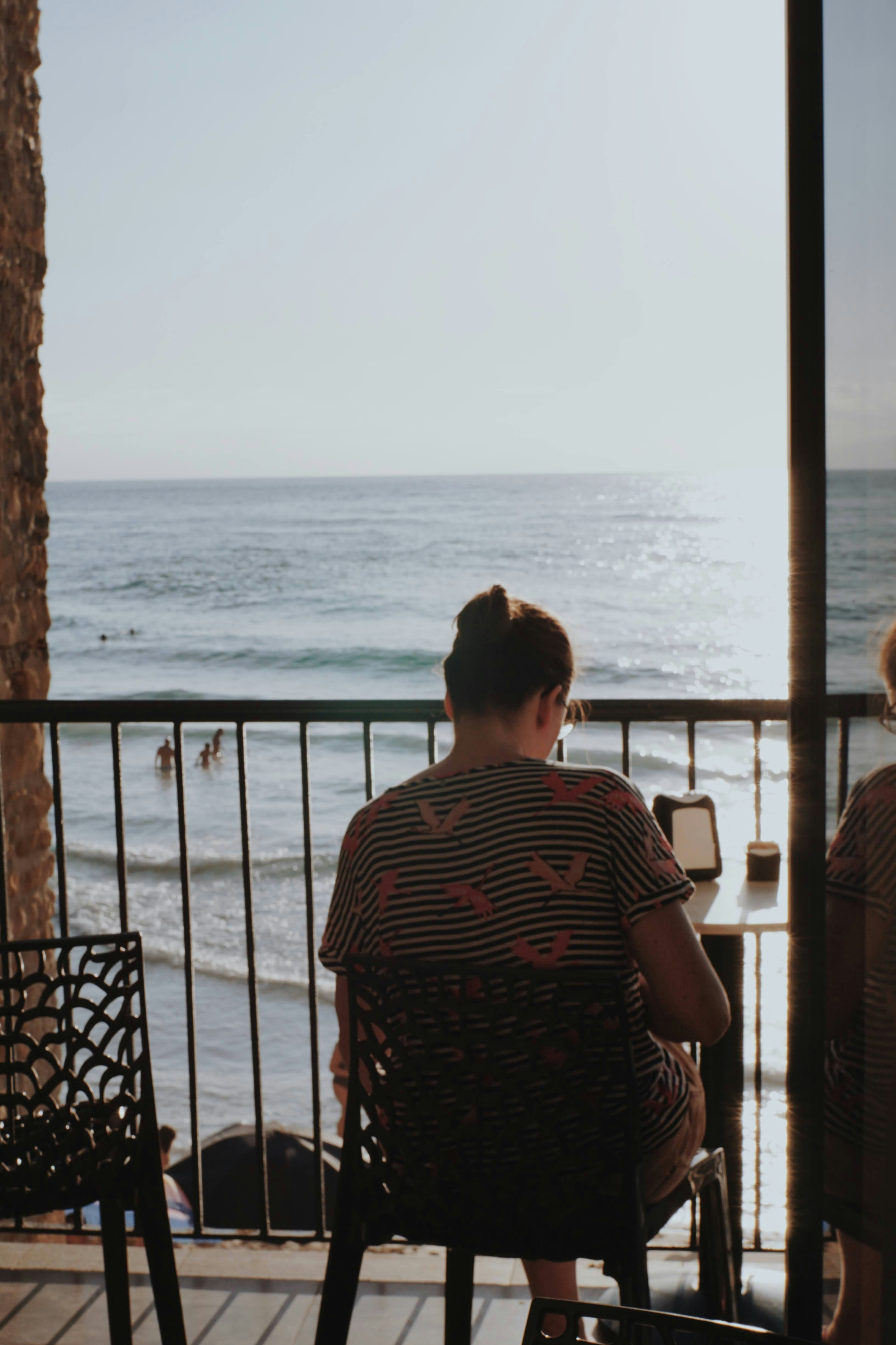 Reading on a balcony above the beach in the late-afternoon sun