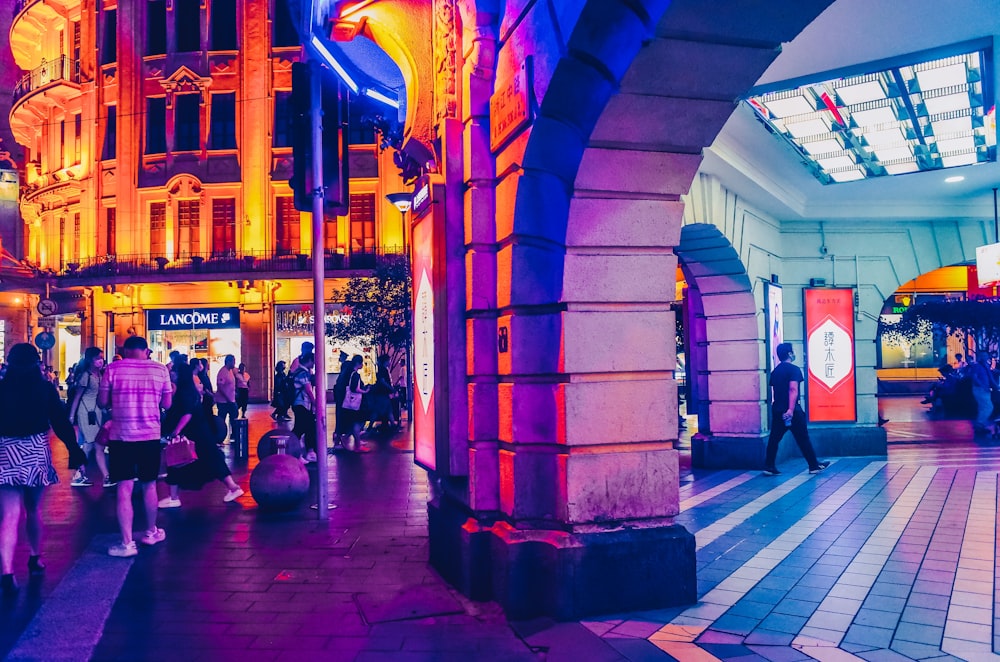 a group of people walking down a street next to tall buildings