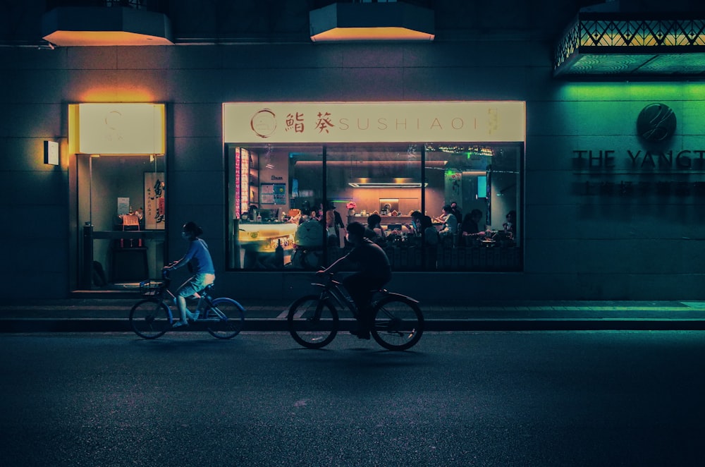 a couple of people riding bikes down a street