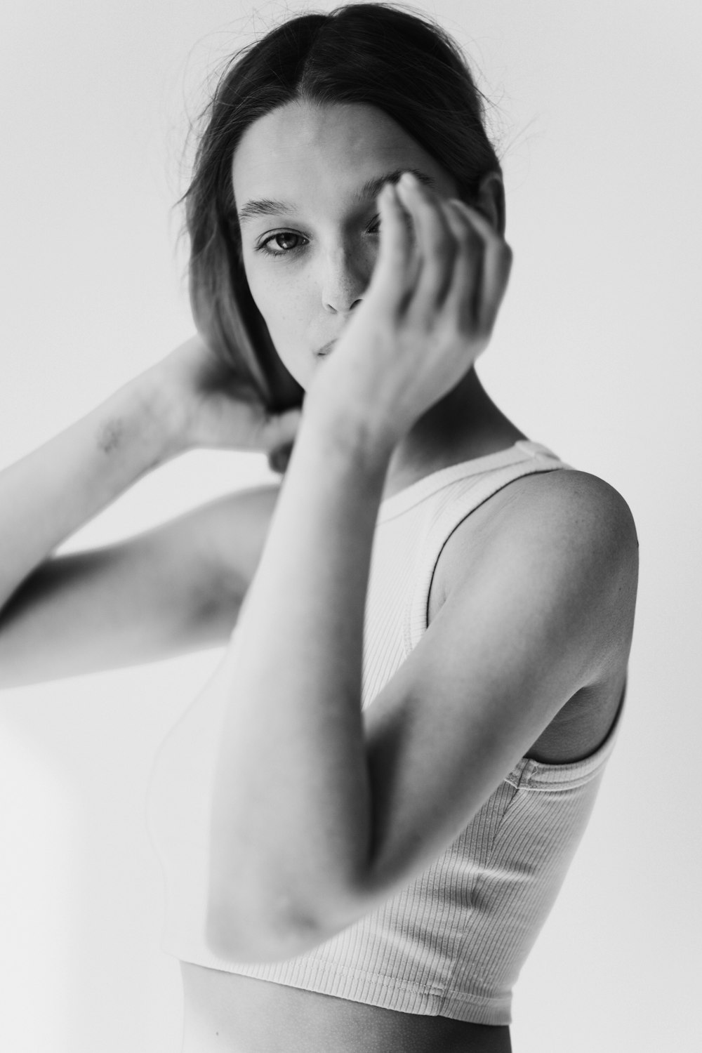 a black and white photo of a woman in a tank top