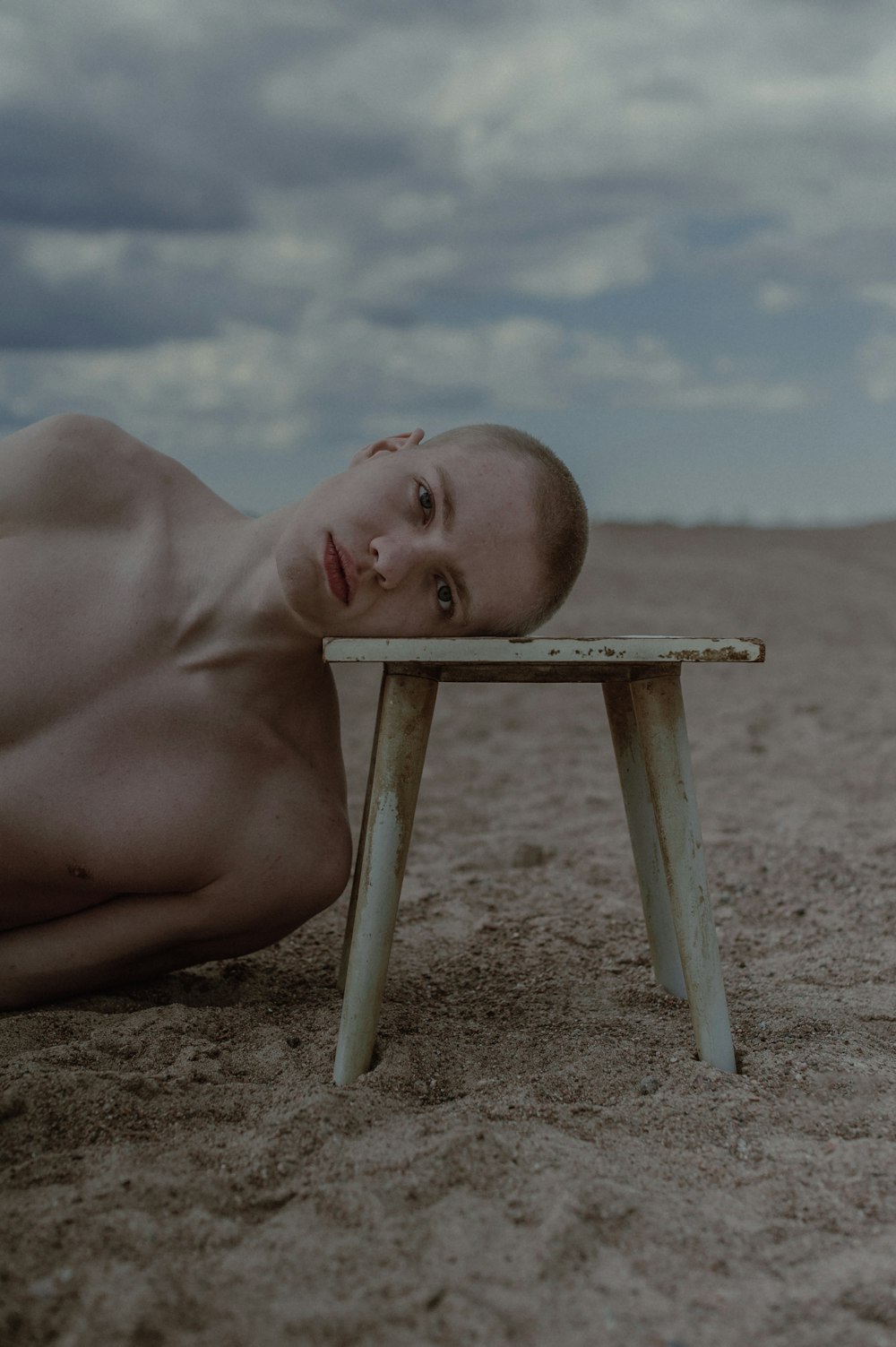 木製のテーブルの上に横たわる裸の男