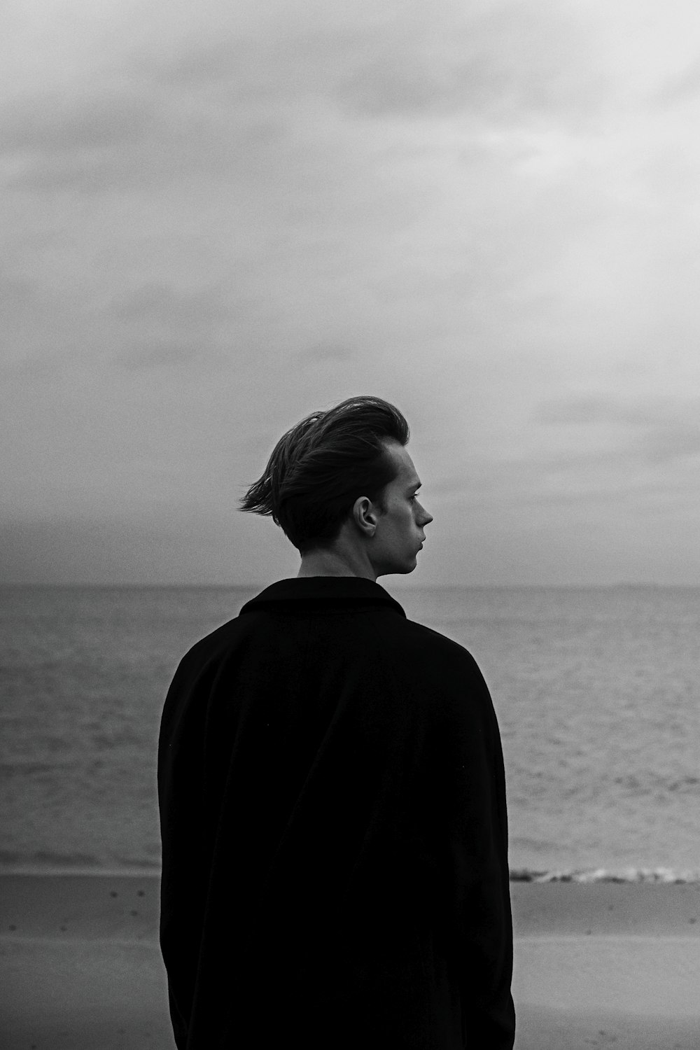 a man standing on a beach next to the ocean