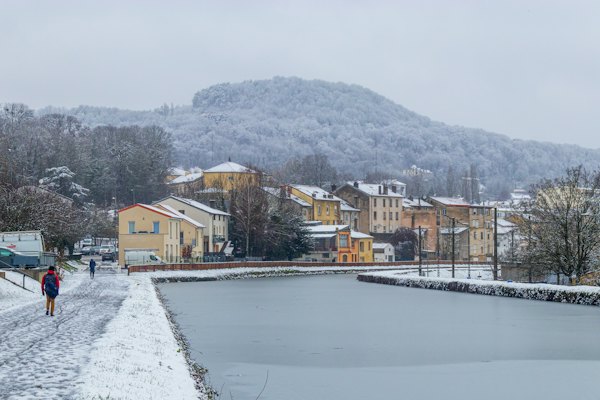 A walker by the water in snow — Nancy, France