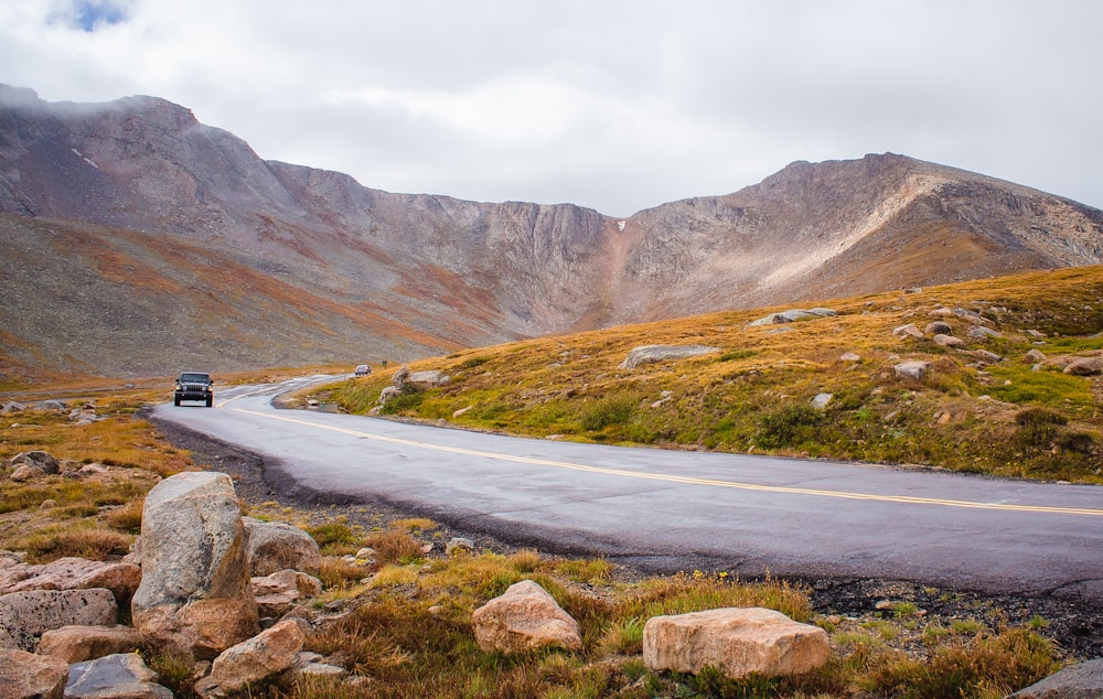 a car driving down a road in the mountains