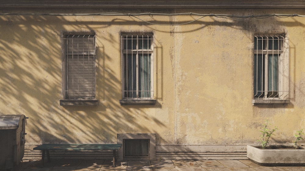 a building with two windows and a bench in front of it