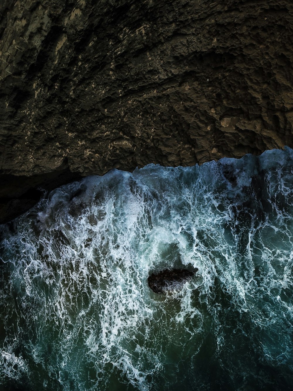 a large body of water next to a cave